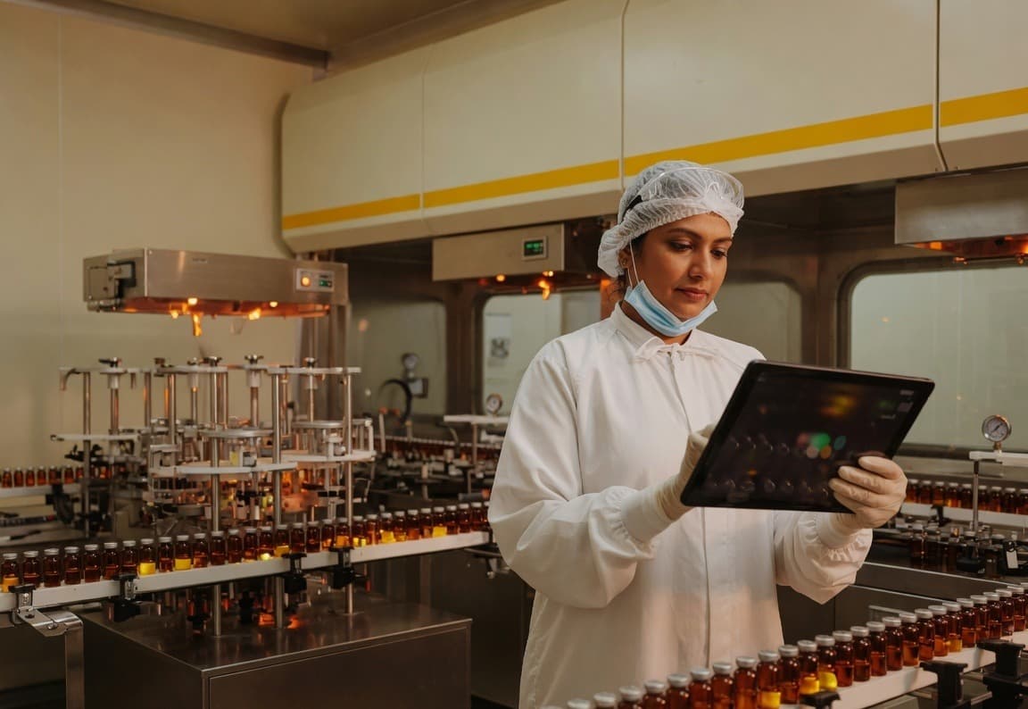 Quality professional reviewing a digital record on a pharmaceutical fill-finish line
